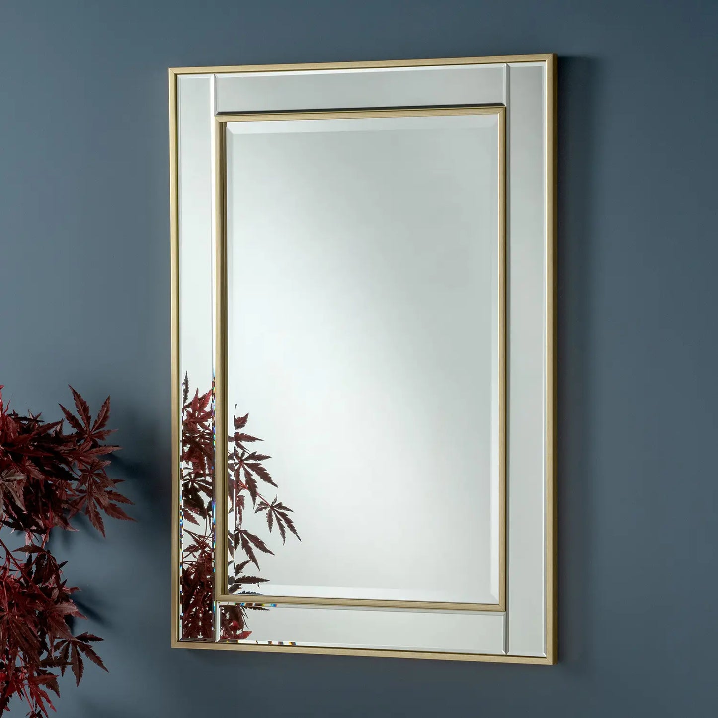 Gold-framed rectangular wall mirror with beveled edges.