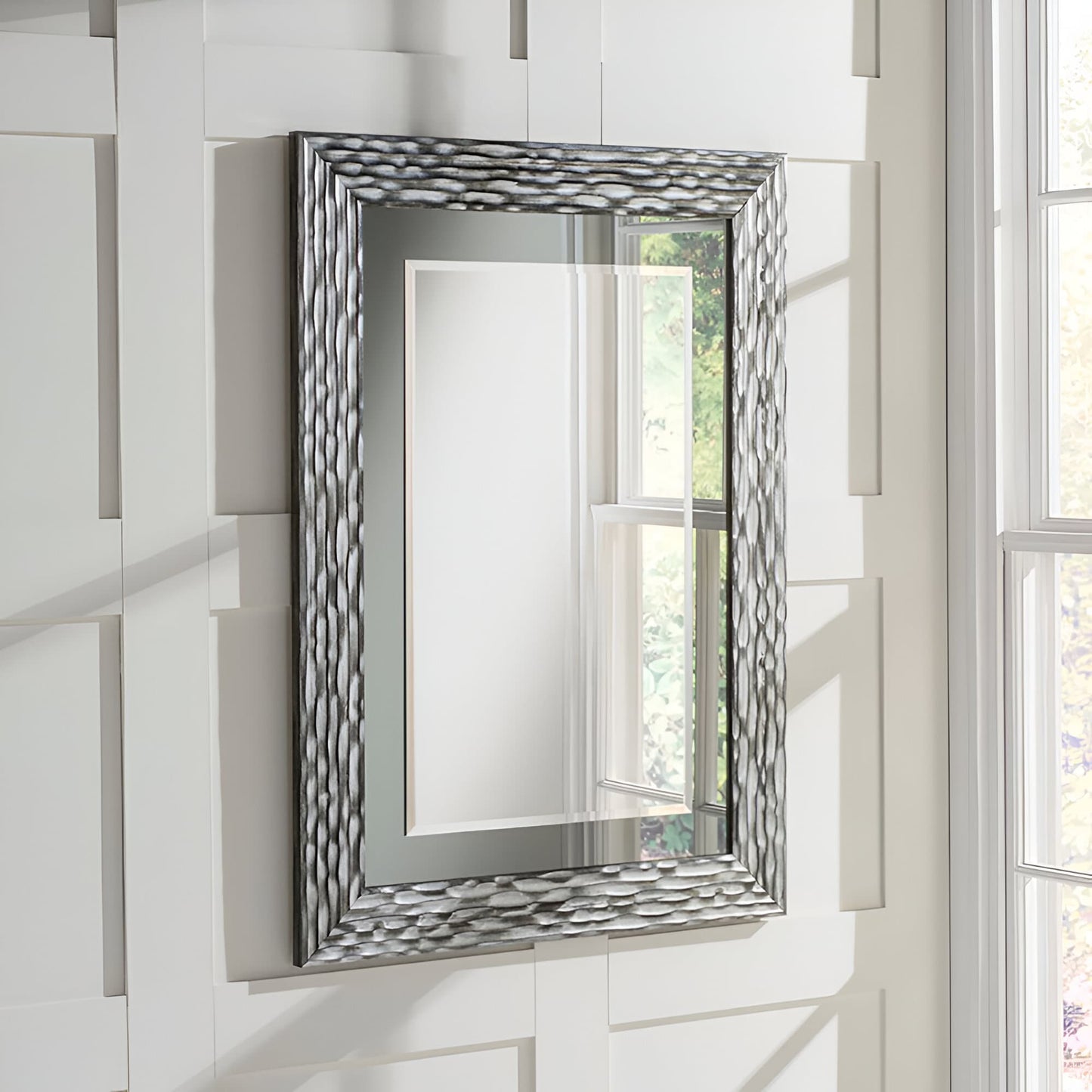 Black and Silver textured framed mirror hanging on a white wall.