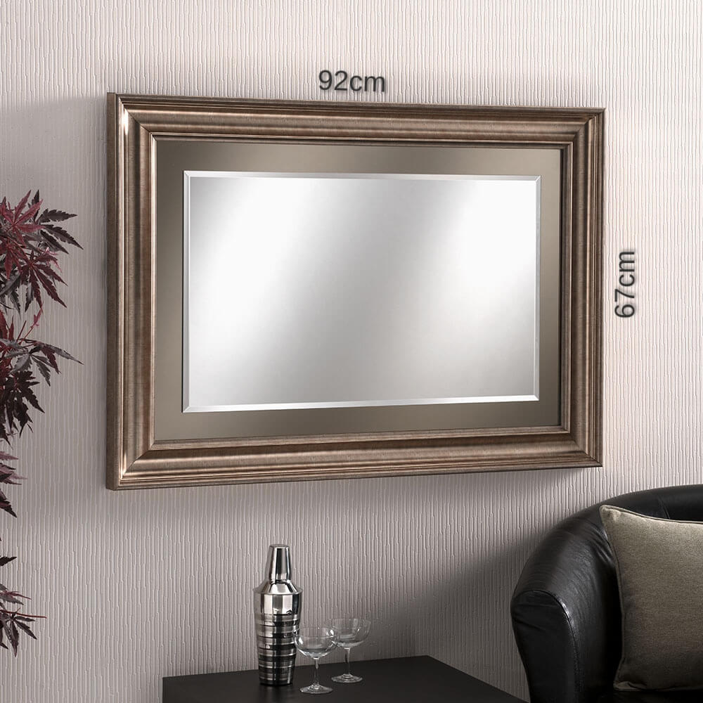 Medium, rectangular wall mirror with a decorative, bronze frame.