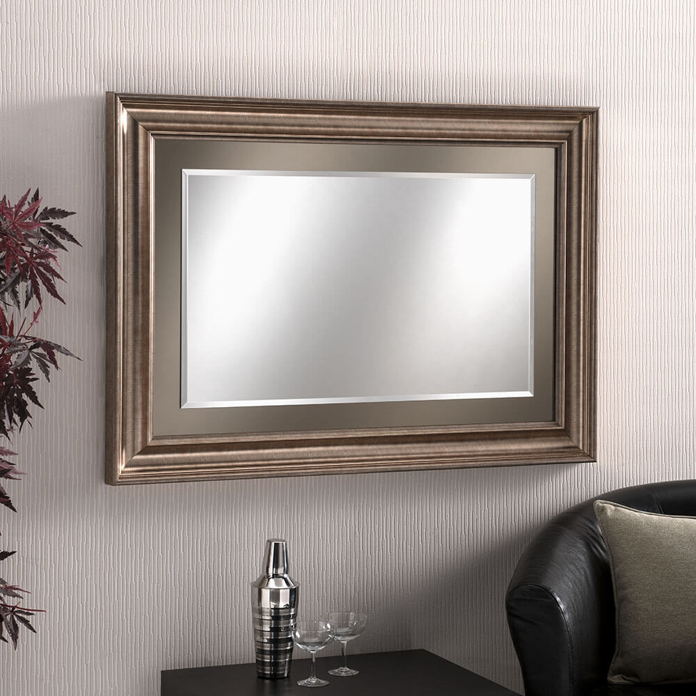 Rectangular wall mirror with a decorative, bronze frame. Can be hung in landscape or portrait orientation.