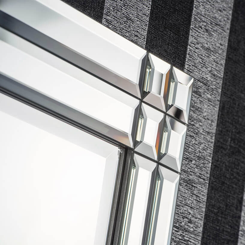 Close-up of a decorative beveled glass mirror with a geometric design.