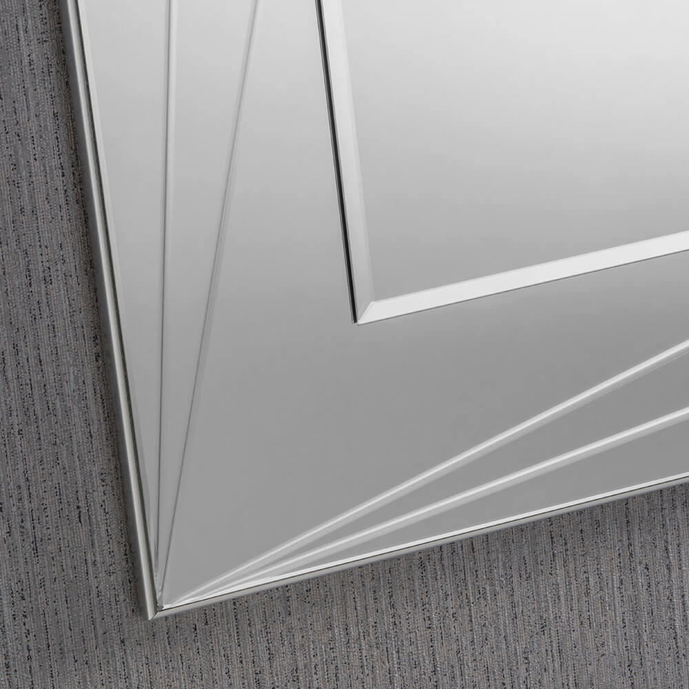 Close-up of a decorative, beveled-edge, silver framed rectangular wall mirror.