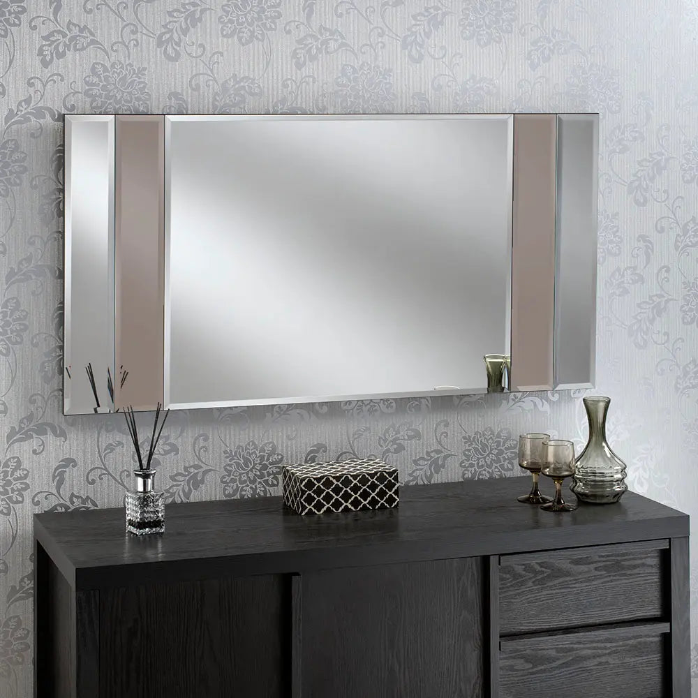 Large, black framed beveled wall mirror with vertical bronze dividers, above a dark wood vanity.