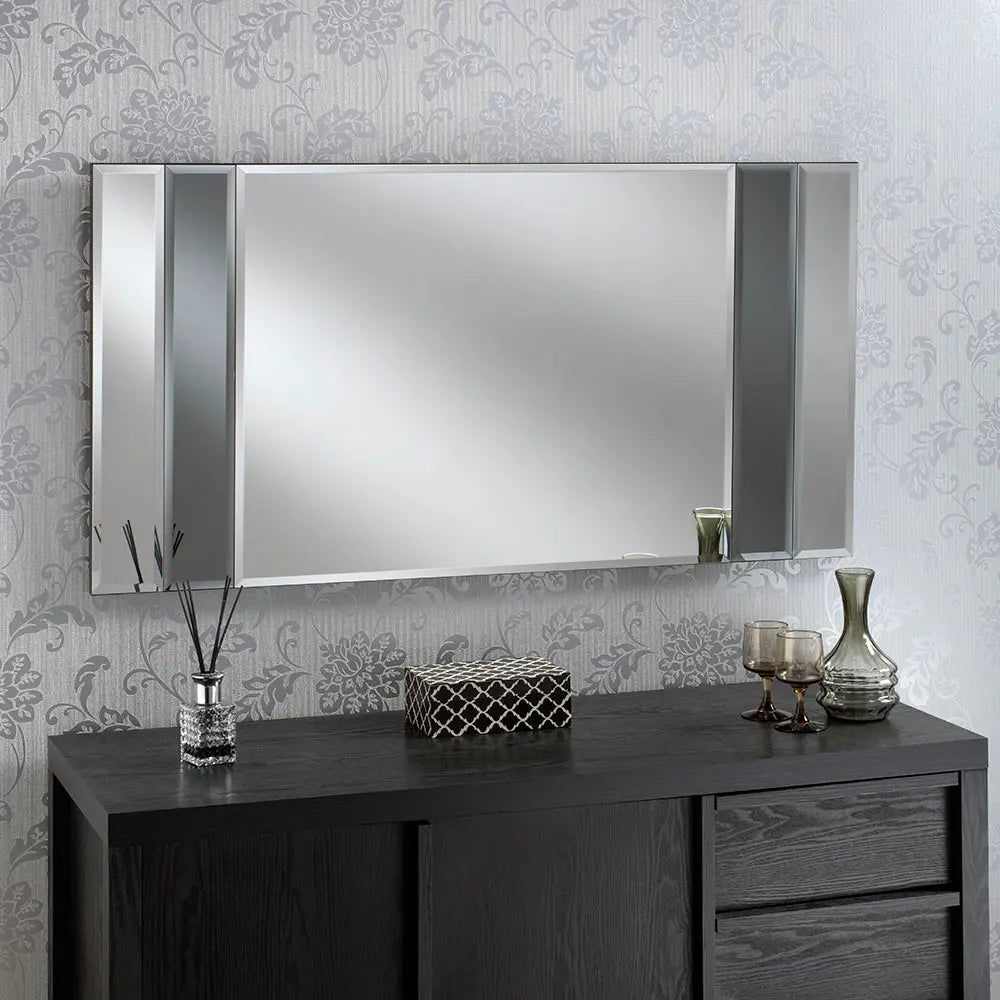 Large, black framed beveled wall mirror with vertical grey dividers, above a dark wood vanity.