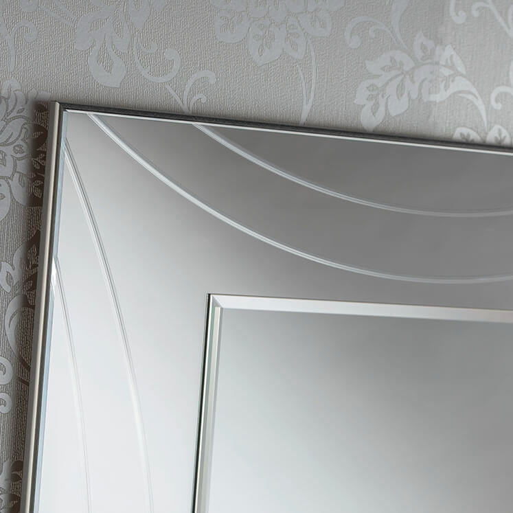 Decorative, beveled-edge silver frame surrounds a large, reflective rectangular mirror.