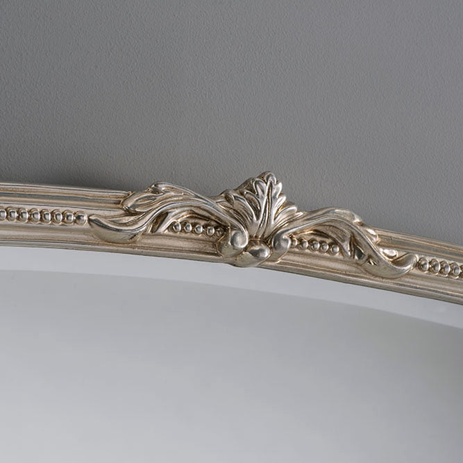 Ornate silver-toned arch mirror frame with detailed leaf and acanthus scrollwork.