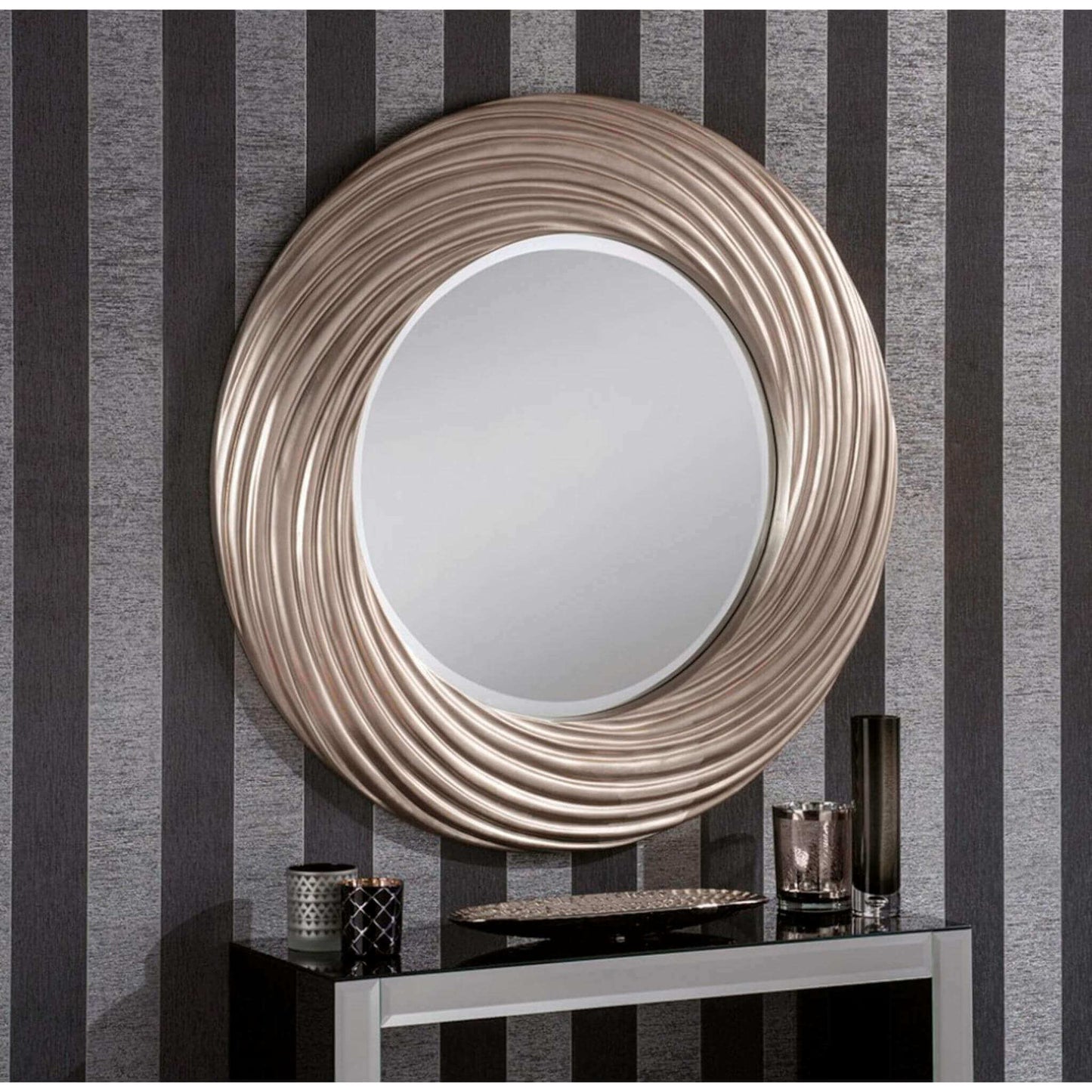 Silver circular wall mirror with a textured, swirled frame, hung above a mirrored console table.