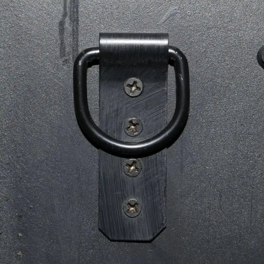 Black metal bracket attachment with four screws on a dark gray surface.