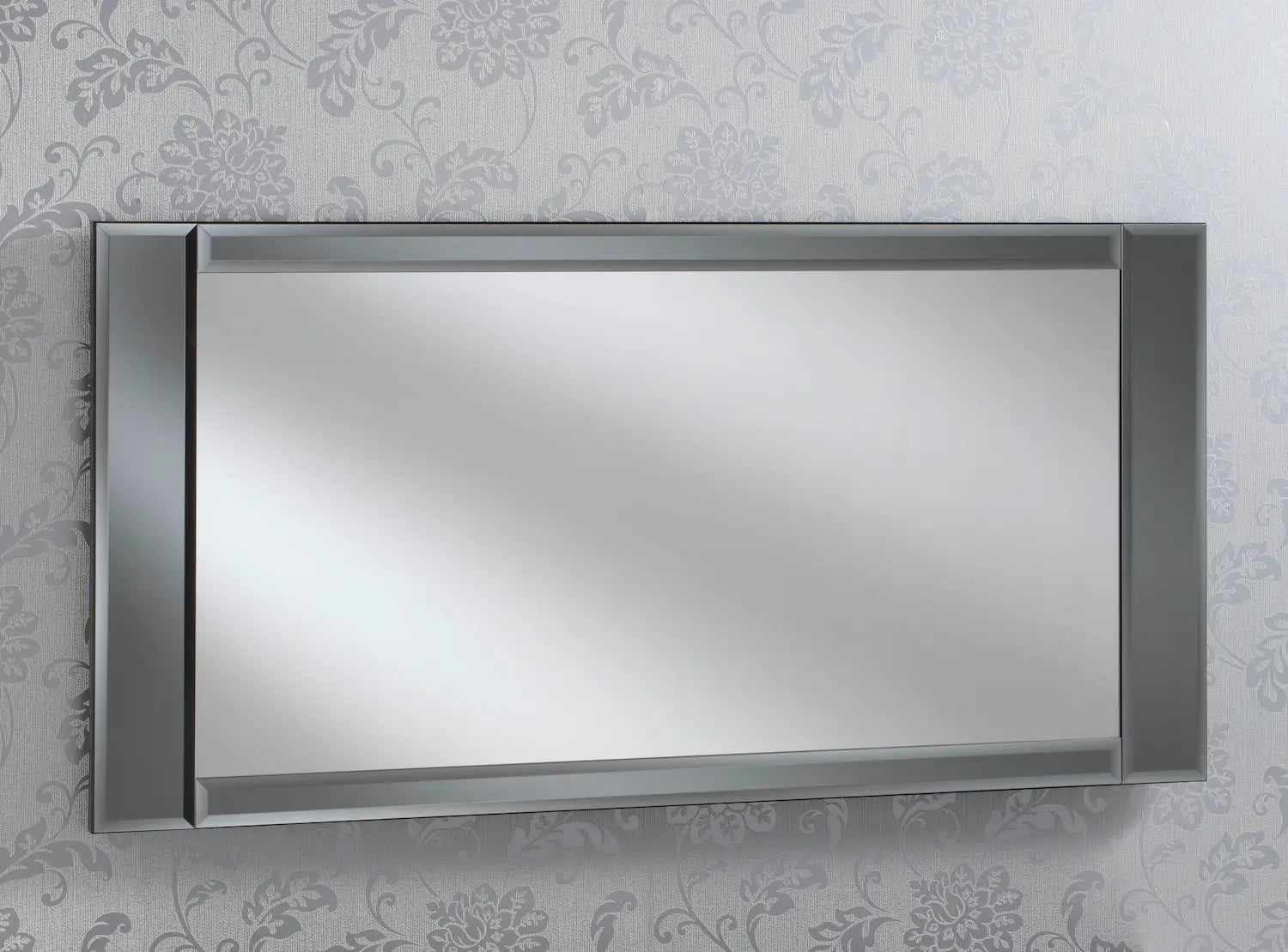 Large rectangular wall mirror with a dark frame, hung against a wallpaper with a floral pattern.