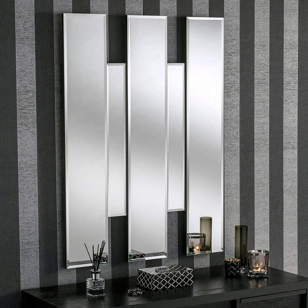 Modern, multi-panelled mirror with silver frames, set against a dark gray striped wall.