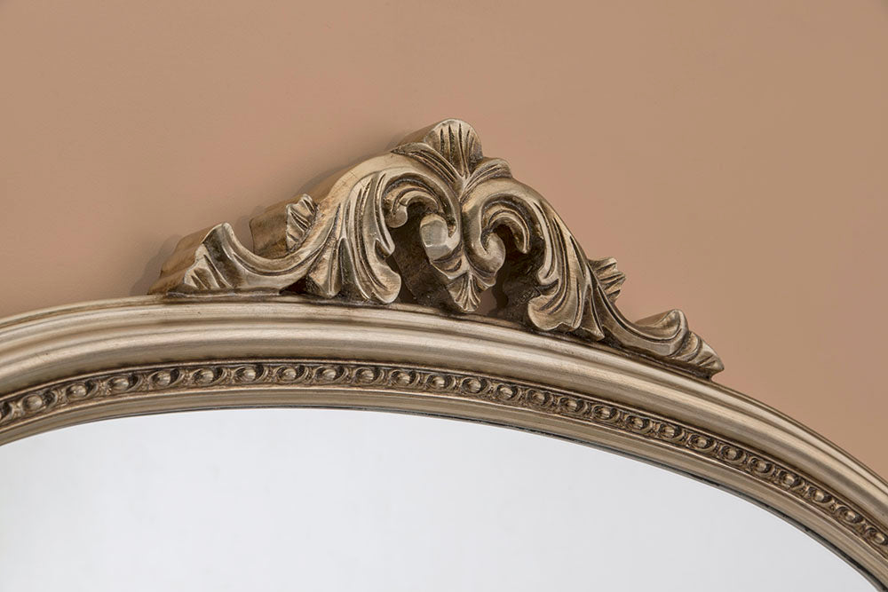 Ornate, beveled-edge arch mirror with decorative, detailed silver-toned frame.