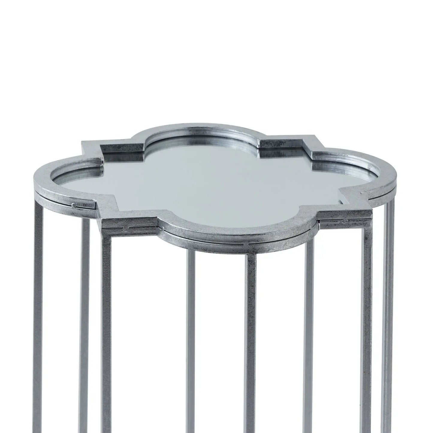 Small, decorative, silver-toned metal end table with a mirrored, quatrefoil-shaped top.
