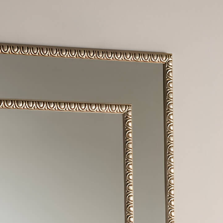 Decorative gold-toned mirror frame with scalloped detailing.