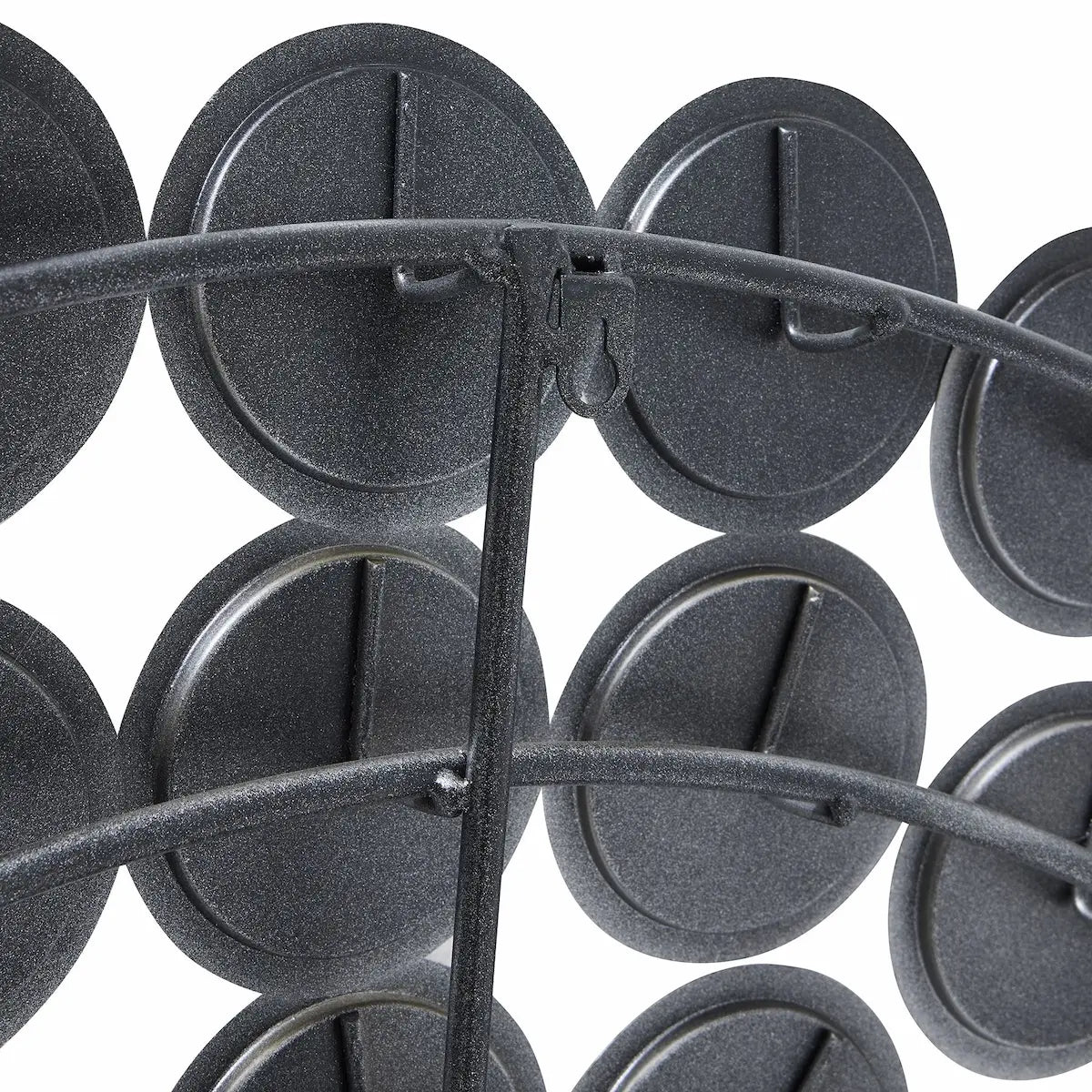 Detailed view of the mirror's backside, showing the dark, textured backs of the individual mirror segments and the supporting metal bracket.