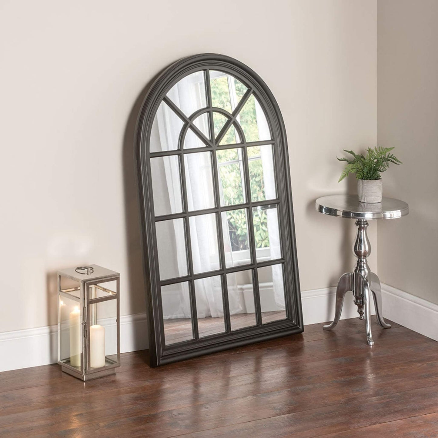 Trendy over-mantel mirror simulating cottage pain window design with an arched top frame in the colour black